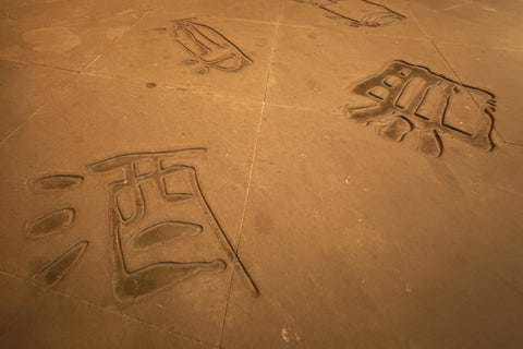 Carved symbols on a stone floor with a dark background